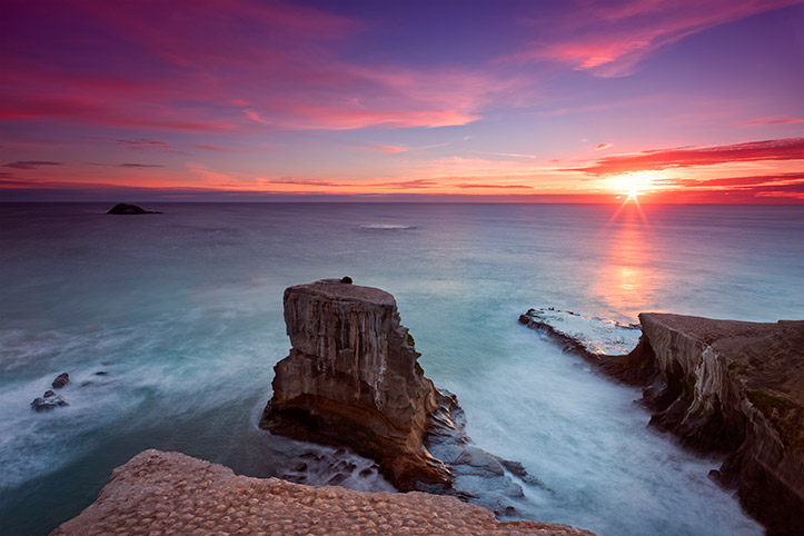 Muriwai Beach Sunset West Coast New Zealand Auckland Rocks Gannet Colony Red Blue Sky Ocean Water Sea Paul Reiffer Photographer Landscape Long Exposure Seascape